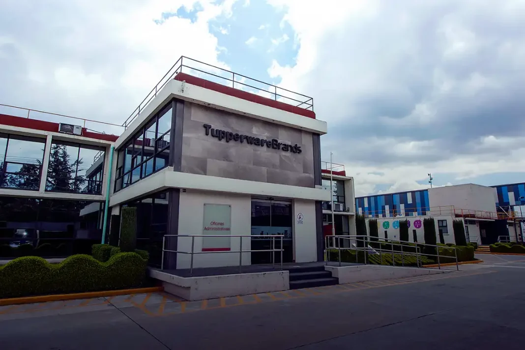 Fachada principal de la planta de Tupperware Brands en México, con oficinas administrativas visibles y señalización corporativa, durante la conmemoración de su 59° aniversario de operaciones.