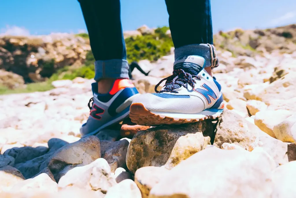 Tenis New Balance de mujer para caminar en terreno rocoso con diseño deportivo y suela resistente